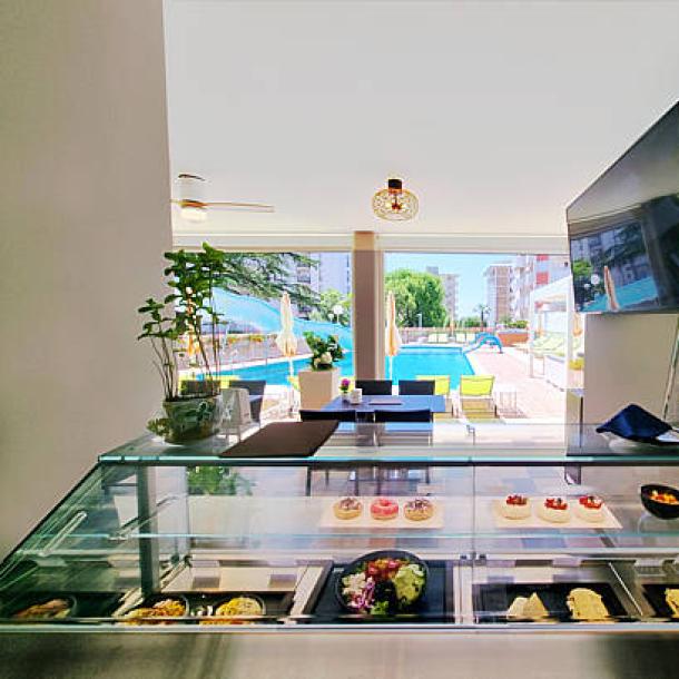 Dessertvitrine mit Blick auf Pool und Entspannungsbereich.